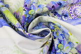 Swirled swatch Floral Stripe fabric (white fabric with large striped clusters of floral design in blue, purple, green shades with floral heads, leaves and paisley look design)