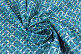 Swirled swatch Flower Chain fabric (dark blue fabric with floral geometric style design allover: small leaves in various teal shades arranged to make a 4 point flower with a small green square center)