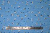 Flat swatch lilies and dandelions blue fabric (light blue fabric with small tossed white and blue lilies and dandelions allover)