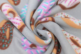 Swirled swatch donuts fabric (medium grey fabric with tan and brown tossed donuts in various icing styles with sprinkles and dots in brown, pink, white, blue, purple colourway)