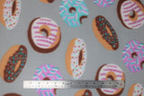 Flat swatch donuts fabric (medium grey fabric with tan and brown tossed donuts in various icing styles with sprinkles and dots in brown, pink, white, blue, purple colourway)