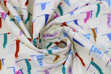 Swirled swatch Green Flags fabric (white fabric with loosely spaced blue post drawn flags with various coloured sails/flags: blue, green, pink, red, purple, etc. with words such as "Love" "Bravery" "Compassion" etc on them)