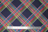 Flat swatch colourful plaid fabric (navy fabric with thick stripes crossing to make plaid, stripes composed of smaller individual stripes in white and rainbow colours)