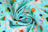 Swirled swatch blue fabric (teal blue fabric with tossed small green cacti in pots and tossed white and grey llamas with polka dots and colourful decorative saddles)