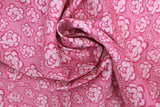 Swirled swatch of peony printed fabric in pink (medium pink fabric with light pink cartoon peony heads tossed)