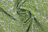 Swirled swatch of peony printed fabric in white (white fabric with light green cartoon peony heads tossed)