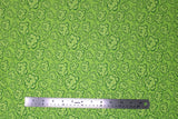 Flat swatch of peony printed fabric in green (lime green fabric with light green cartoon peony heads tossed)