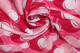 Swirled swatch blotches printed fabric in pink (medium pink fabric with light pink, dark pink/red, and white coloured circular blotches collage)