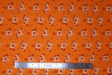 Flat swatch cartoon chicks printed fabric in orange (bright orange fabric with occasional dark orange/red polka dots and white/orange cartoon baby chickens tossed allover)