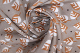 Swirled swatch small leaves printed fabric in grey (grey fabric with tossed cartoon white/brown leaves and small occasional black polka dots)
