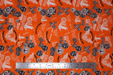 Flat swatch of assorted Friday the 13th pattern on orange (bright medium orange fabric with multi emblems tossed in black and white. Crossing checkered flags, 13 badges, "Port Dover Motorcycle Rally" text, wheels, etc.)