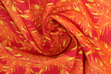 Swirled swatch big leaves printed fabric in orange (dark orange/red fabric with orange and yellow leafy pattern allover)