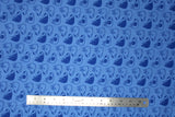 Flat swatch of puppy heads printed fabric in blue (blue fabric with dark blue doodled puppy heads tossed)