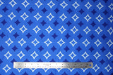 Flat swatch of blue fabric in diamonds (medium blue fabric with dark blue solid diamond star shapes and white outline diamond star shapes tiled)