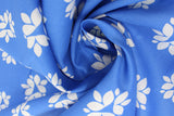 Swirled swatch of blue fabric in lotus (bright blue fabric with white lotus shapes in medium and large sizes tiled)