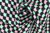 Swirled swatch of assorted moderns printed fabric in scales (black, pink, teal scalloped scale look pattern fabric)