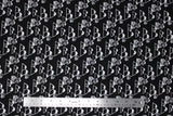 Flat swatch of mountain cabins printed fabric in black (black fabric with tossed white cartoon mountains and cabin print repeated)