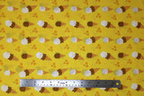 Flat swatch food printed fabric in ice cream cones (yellow fabric with tossed vanilla, chocolate, and combined ice cream scoops in brown cones and tossed orange cherries)