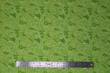Flat swatch of assorted moderns printed fabric in squiggly (light green fabric with white and dark green abstract squiggly lines tossed allover)