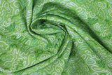 Swirled swatch of assorted moderns printed fabric in squiggly (light green fabric with white and dark green abstract squiggly lines tossed allover)