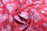 Swirled swatch of assorted Canadian custom motorcycles fabric in red (red fabric with tossed logo and text related to Canadian custom motorcycles "Custom" text, etc. in white, black)