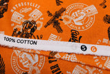 Raw hem swatch of assorted Canadian custom motorcycles fabric in orange (orange fabric with tossed logo and text related to Canadian custom motorcycles "Custom" text, etc. in white, black)