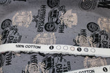 Raw hem swatch of assorted Canadian custom motorcycles fabric in grey (grey fabric with tossed logo and text related to Canadian custom motorcycles "Custom" text, etc. in white, black)