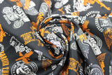 Swirled swatch of assorted Canadian custom motorcycles fabric in black (black fabric with tossed logo and text related to Canadian custom motorcycles "Custom" text, etc. in white, orange)