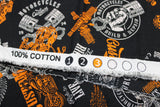 Raw hem swatch of assorted Canadian custom motorcycles fabric in black (black fabric with tossed logo and text related to Canadian custom motorcycles "Custom" text, etc. in white, orange)