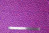 Flat swatch of faux fur fabric in pink/purple print (purple fabric with pink stone like pattern allover)