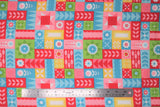 Flat swatch patchwork fabric (red, pink, blue, green, yellow rectangular and square small patches allover containing small floral graphics in white and same colourway)