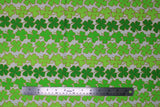 Flat swatch Clover Stripe fabric (white fabric with lines/stripes of clover leaves outlined in gold sparkles all in various shades of green)