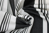 Swirled swatch onyx stripe fabric (white fabric with thick black stripes and groups of small black stripes within the white spaces)