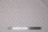 Flat swatch honeycomb fabric (white fabric with subtle grey honeycomb effect in background medium sized and small red honeycomb pattern on top with tossed pink and black small hexagons)