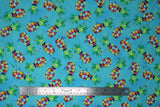 Flat swatch pineapples fabric (teal blue fabric with tossed abstract style pineapples with circular paint blobs in body and wispy green and yellow stems above)