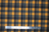 Flat swatch orange and black plaid fabric (medium sized plaid lines in black, grey, blue grey, dark yellow/orange)