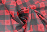 Swirled swatch Canada leaf plaid fabric (black, red, and black with red stripes squares allover to create plaid pattern with dark grey maple leaves within red squares)