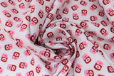 Swirled swatch jam fabric (white fabric with tossed cartoon red jam jars with pink cover with red bow, some have a small "jam" label on front and some have a strawberry)