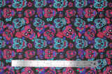 Flat swatch Black/Pink/Green sugar skulls fabric (black fabric with medium sized tossed pink and teal green sugar skulls with pink, teal green and purple tossed floral allover)