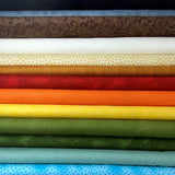 A stack of fabric bolts featuring micro prints in a variety of colours