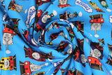 Swirled swatch light blue fabric (light blue fabric with full colour character trains allover in multi directions with "Thomas & Friends" logo tossed)