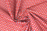 Swirled swatch primary chain fabric (red fabric with diagonal lines of white diamonds with squares of primary colour within all arranged in a chain look pattern)