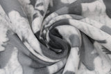 Swirled swatch moose eagle buffalo fabric (light grey fabric with a slight weathered look and grey silhouettes of moose, eagles and buffalo some with grey horizon lines within, tossed directional arrows and "N E S W" letters)