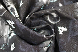 Swirled swatch Witchy fabric (black fabric with repeated outdoor graphic/scene with dark graveyard and white moon and ghosts with black witch on broom silhouette and bats, etc.)