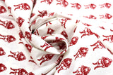 Swirled swatch yuletide themed printed fabric in Red Santas on White